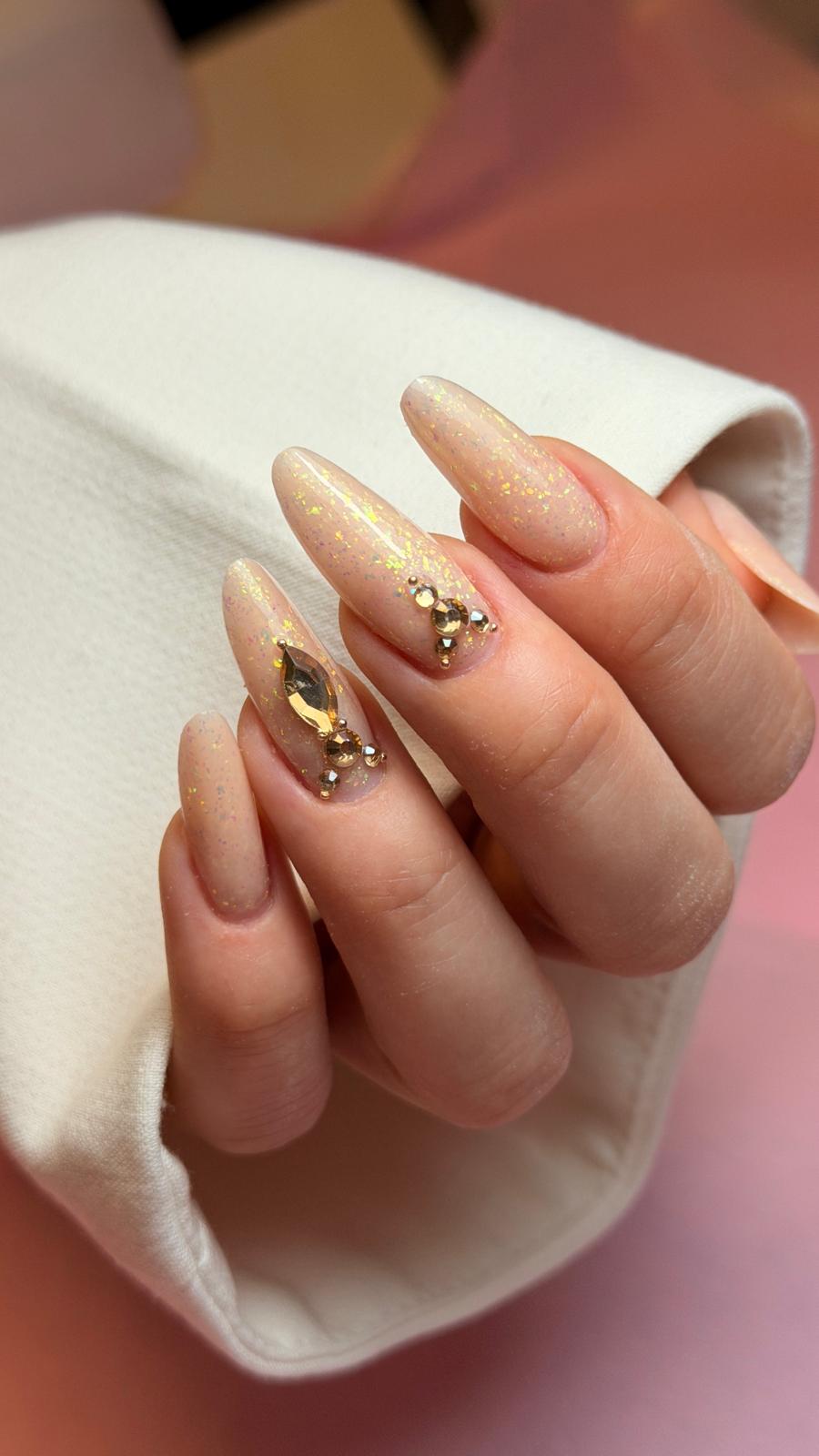 Beżowe paznokcie migdałki ze złotymi zdobieniami