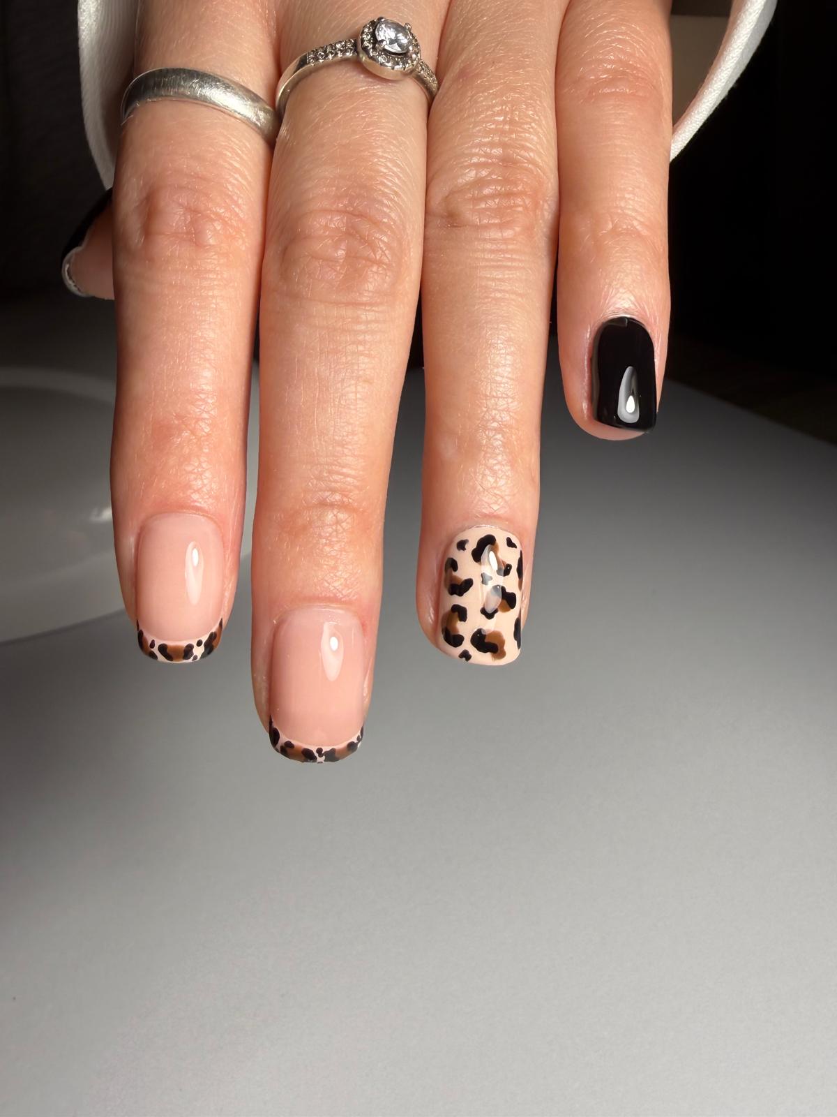 Krótki manicure z motywem panterki i czarnymi detalami